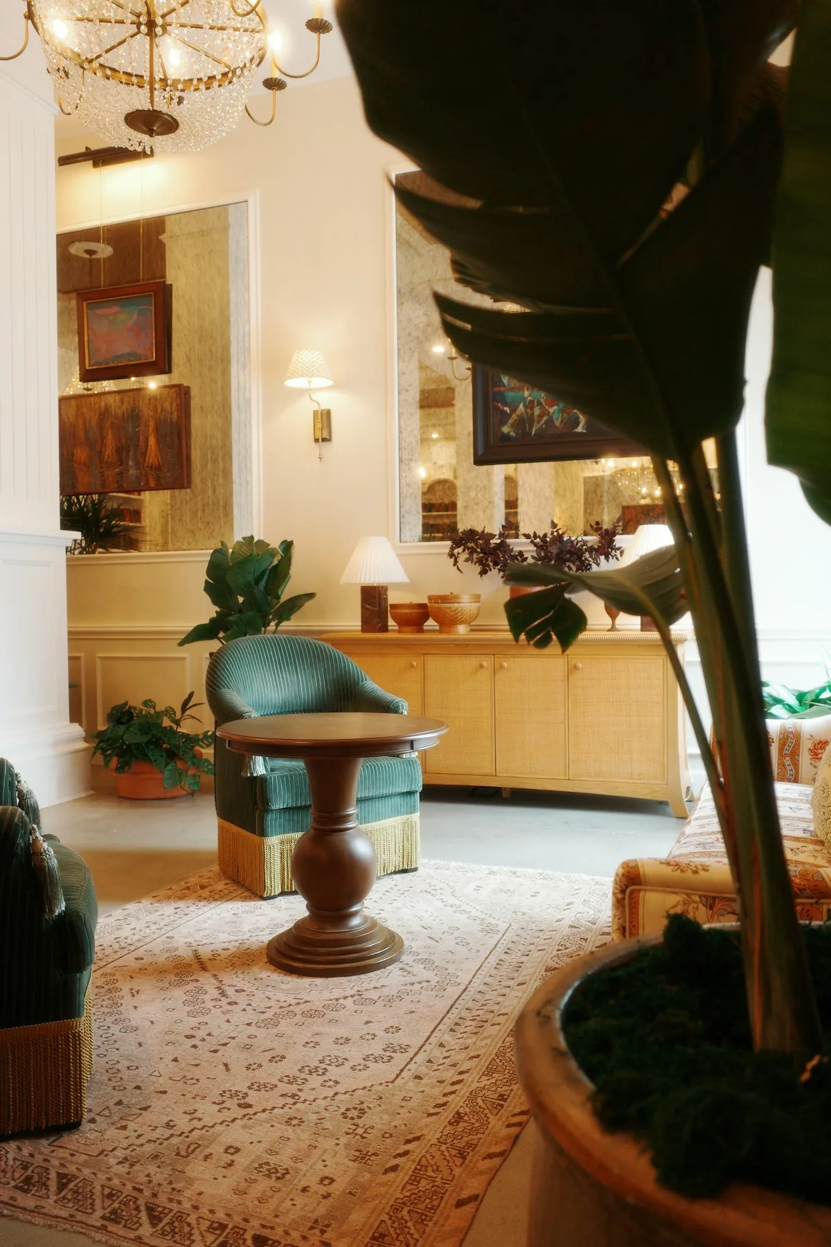 Green armchairs and timber tables in a warm hotel lounge